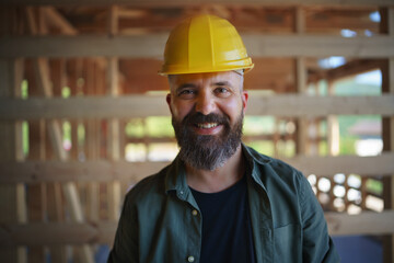 Portrait of construction worker smiling and looking at camera, diy eco-friendly homes concept.