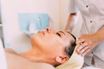 Fototapeta na wymiar Cosmetologist does facial massage for woman. Beauty skin care