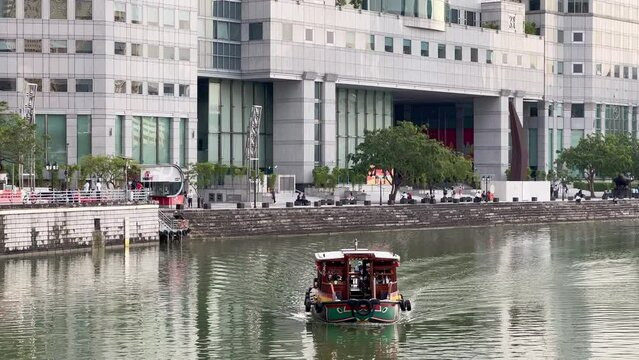 Tour the city with famous scenic river cruise, bumboat ride, boat sailing on calm water towards the camera at daytime, Singapore Southeast Asia.