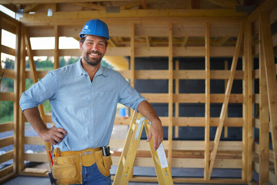Portrait of construction worker smiling and looking at camera, diy eco-friendly homes concept.