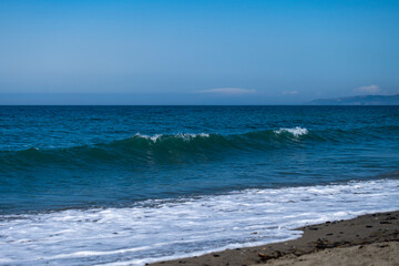 Fototapeta na wymiar Ocean waves crashing on sandy beach. Sea waves breaking on Maditerranean's shore.
