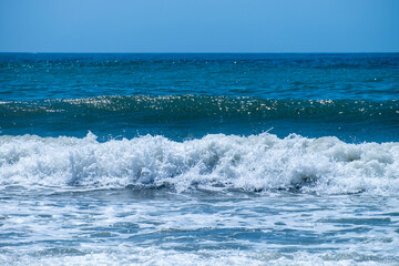 Ocean waves crashing on sandy beach. Sea waves breaking on Maditerranean's shore.