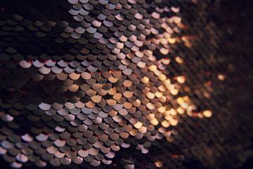 Glamorous background of multi-colored sequins, sequins. Sequins on the fabric, selective selective soft focus. Sequins shimmer in the sun