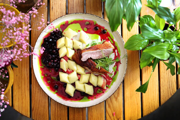 Duck breast with kopytka, Polish potato dumplings, glazed beetroot and blackcurrant emulsion, top view, selective focus