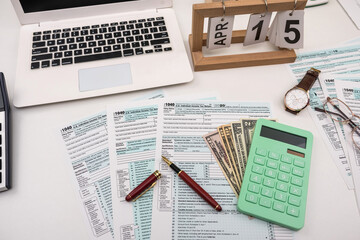 Blank personal income tax return with dollar bills and calculator and pen on calendar