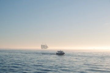 Fototapeta na wymiar Sailing ship at sea at sunset on the horizon