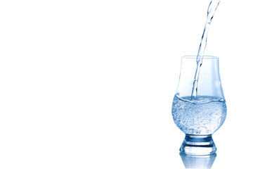Mineral water pouring into spirit  glass isolated on white background.	