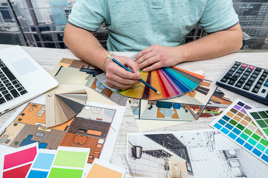 designer selects  color for the walls of the new apartment the picture he holds in his hand