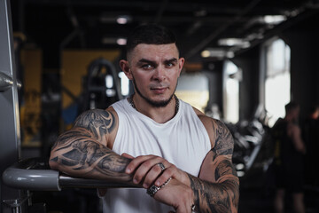 Fototapeta premium Handsome tattooed bodybuilder looking fiercely to the camera