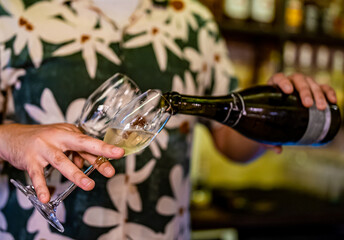 Bartender pouring champagne into glass in bar