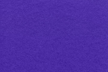 Texture of navy blue and violet colors paper background, macro. Structure of dense craft indigo cardboard.