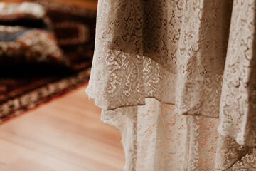 A beautiful lace wedding dress detail. Stunning white details, pretty style. Brown background copy space. Big day preparation design.	