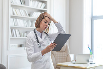 Side view on female physician standing and holding gadget and documents of patients. Modern health care concept