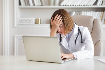 Tired female physician feeling bad after exhausted work day in the office of modern clinic