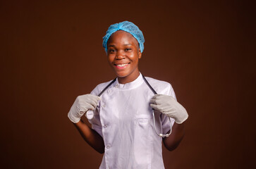 Happy young nurse looking at camera isolated on brown