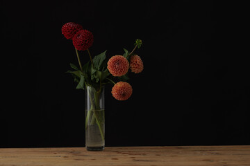 glass vase with dahlia on wooden table, dark background, mockup