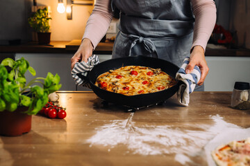 woman preparing homemade pizza in her kitchen