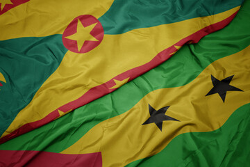 waving colorful flag of sao tome and principe and national flag of grenada.