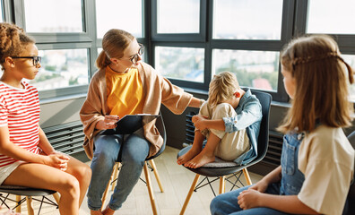 School psychologist with a group of  children conducts a mental health lesson, group therapy, a psychotherapy session
