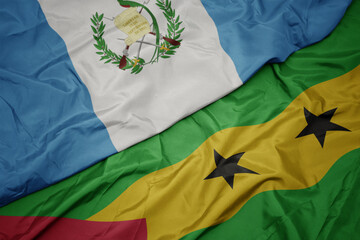 waving colorful flag of sao tome and principe and national flag of guatemala.