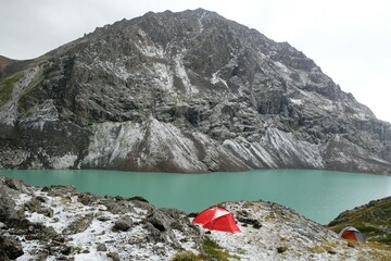 Red tent on bank of Lake Ala-Köl (Ala-kol, Ala-kul) in Tien Shan mountains in west of Kyrgyzstan,...