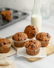 Banana chocolate chip muffin on wood and bottle milk on white background