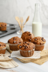Banana chocolate chip muffin on wood and bottle milk on white background