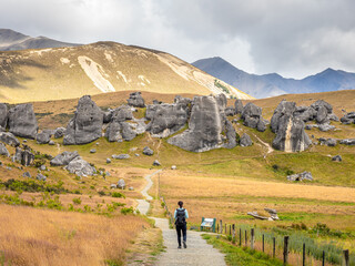 A tourist is walking to Castle Hill Conservation Area in Arthurs Pass National Park, New Zealand.