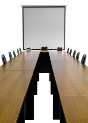 Isolates of long wooden tables and chairs in front of the projection screen in the meeting room.