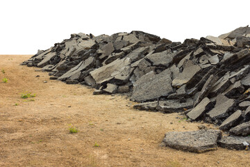 Isolates background ensemble pieces of asphalt road which lay heaped on the ground to be recycled.