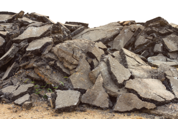 Isolates background ensemble pieces of asphalt road which lay heaped on the ground to be recycled.