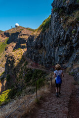 Naklejka premium A young woman on the trail to the Ninho da Manta viewpoint on Pico do Arieiro, Madeira. Portugal