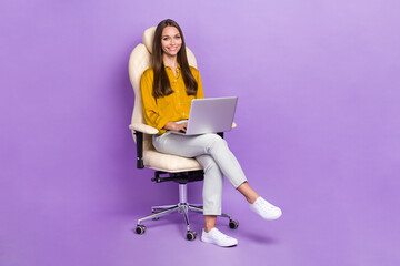 Full length photo of lady sit work laptop wear blouse trousers boots isolated on purple color background