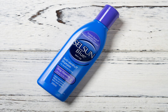ZHONGSHAN GUANGDONG China-November 29,2021:bottle of Selsun Blue anti-dandruff shampoo on wood background.