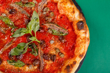 Pizza napoletana gourmet con sugo di pomodoro, basilico fresco, acciughe, olive nere e origano...