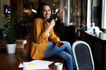 Young businesswoman drinking coffee in her office. Woman enjoy in coffee break.