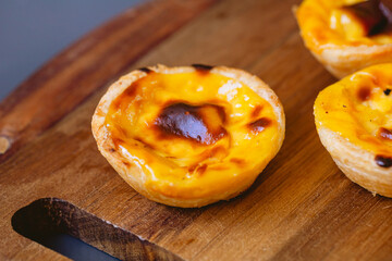 Pastel de Belém ou Pastel de Nata. Pastéis de belém sobre uma tábua de madeira pronto para...