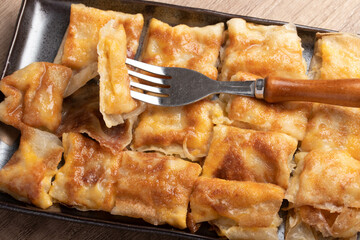 Crispy roti topped with milk in a black plate