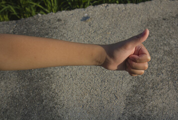 
It is a child's hand with a raised thumb.