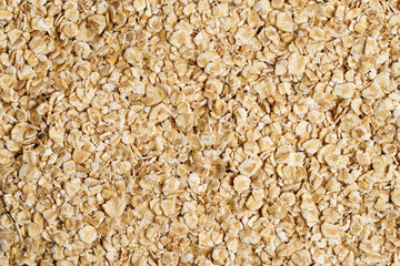 Rolled oat, oat flakes background or texture. Close up, directly above