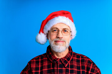 Handsome senior bearded man holding gift box and wish a Merry Christmas and a happy new year