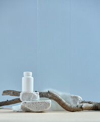 Mockup plastic jar on stone podium on light blue backdrop. Empty scene with twig for dietary...