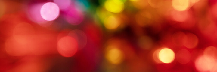 Blurred bokeh background for Christmas and New Year holiday. Abstract colorful wallpaper with defocused lights. Copy space. Banner