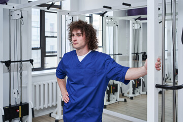 Fototapeta na wymiar Physical therapist standing at the rehabilitation centre while working with different equipment