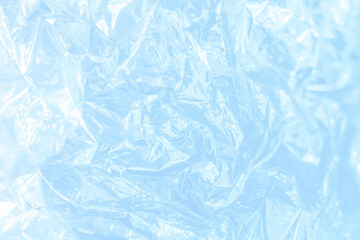 Iridescent foil texture background. Holographic wrinkled surface. Vibrant blue gradient template...