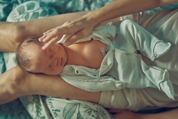A newborn baby is lying on his mother's lap