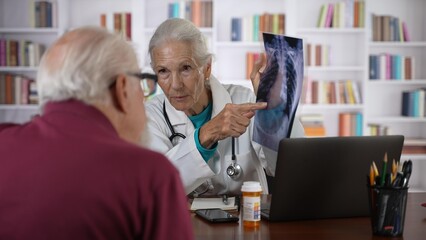 Woman doctor shows X-Ray film to an elderly man old patient, provide professional medicare health insurance.