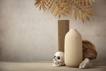 Minimalist monochrome still life composition with ceramic vase, cardboard podium, crumpled paper, natural stone, miniature skull and leaves in beige color