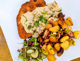paniertes Schnitzel mit Bratkartoffeln und Salat