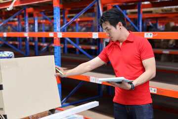 Warehouse workers young asian man working and using tablet, walkie talkie radio and cardboard while...